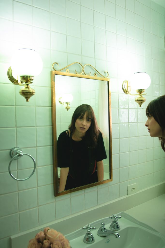 Woman in Black T-shirt Staring on Wall Mirror