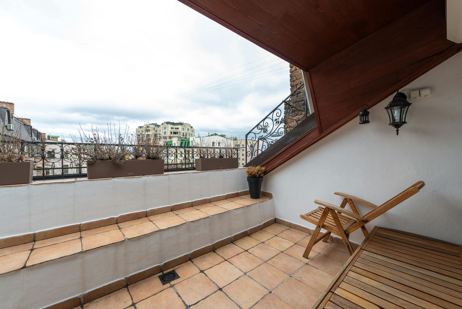 Terrace with armchair on tiled floor in city