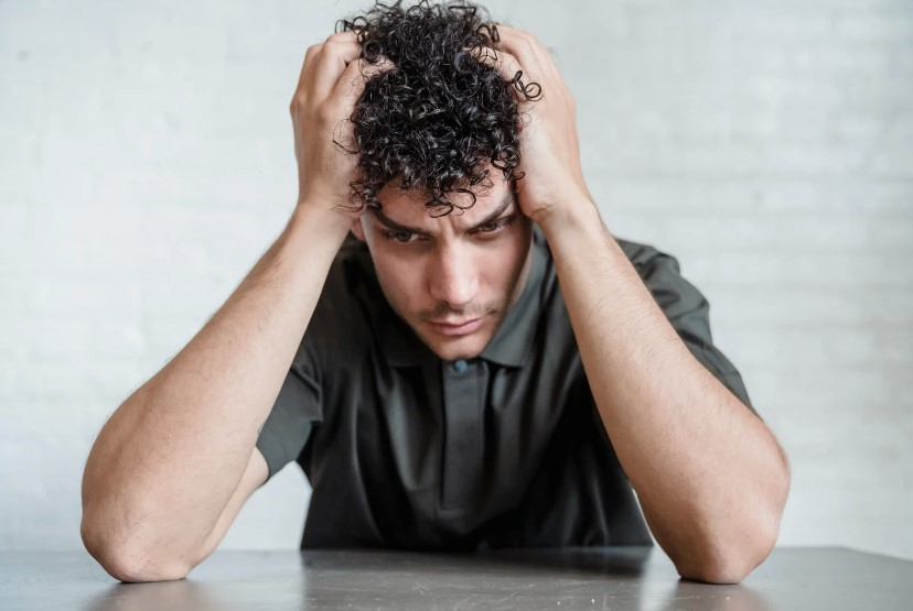 Man holding his head as his thoughts are cluttered with mental noise