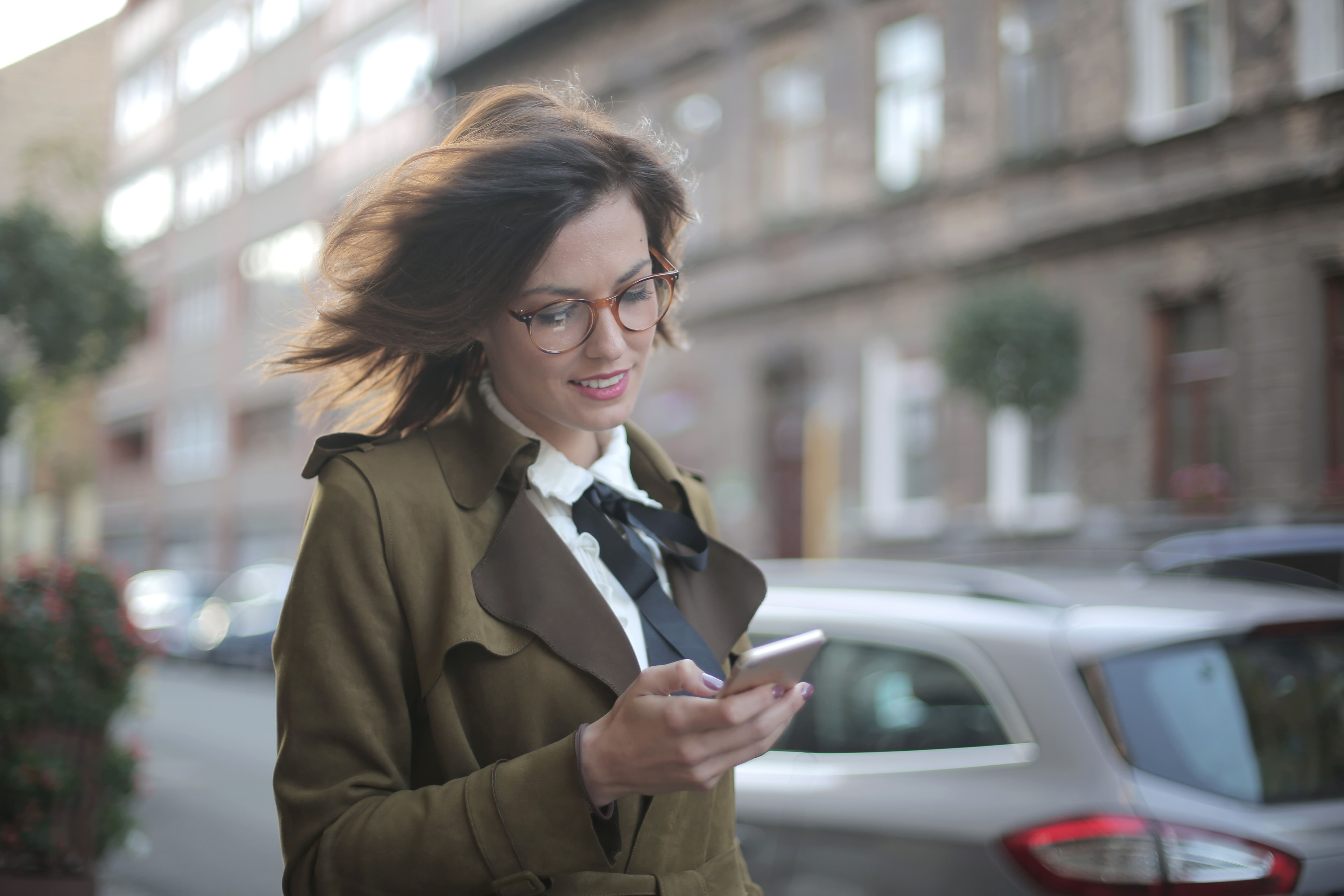 Professional woman chatting on phone in white collar attire in the city