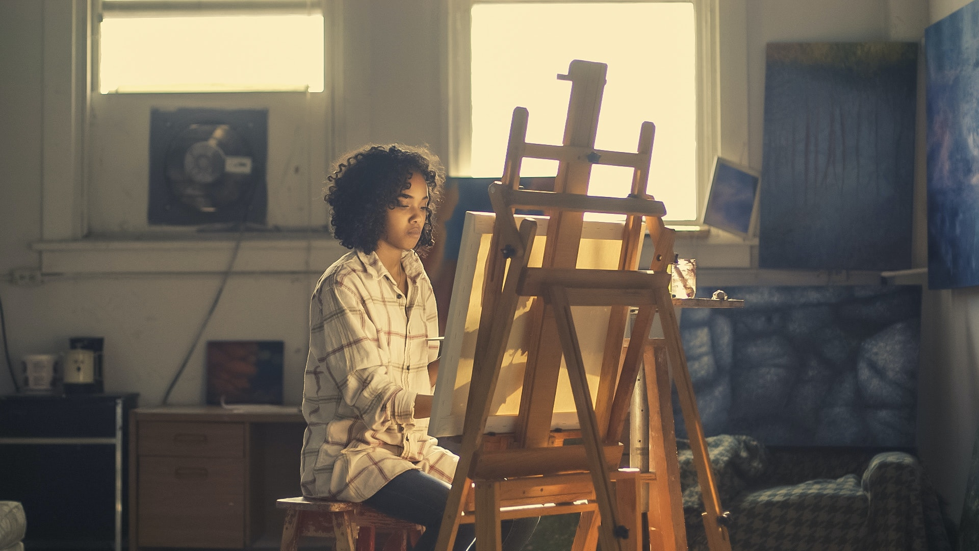 woman painting in sunlit room