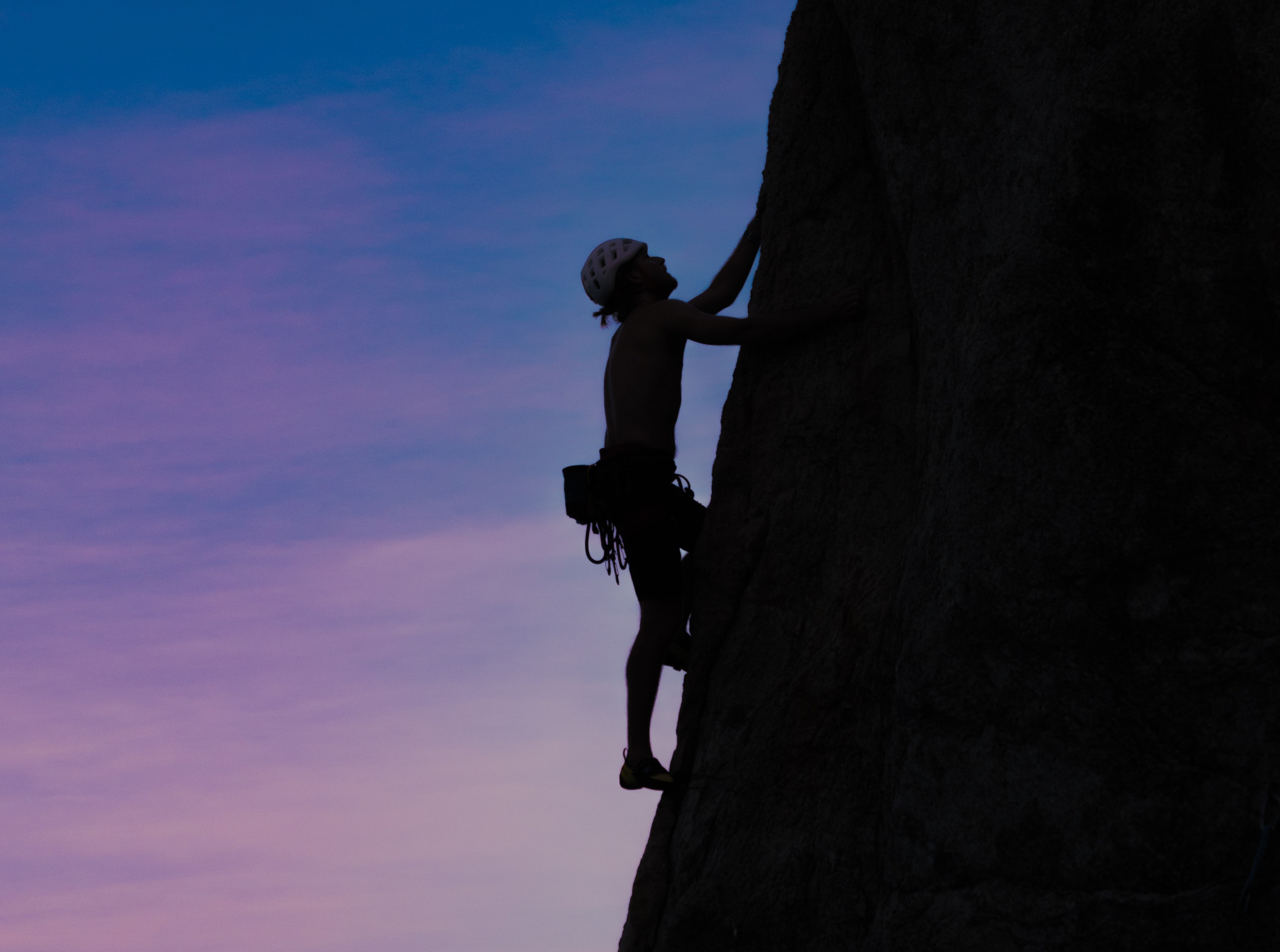 Silhouette of mountain climber and steep mountain