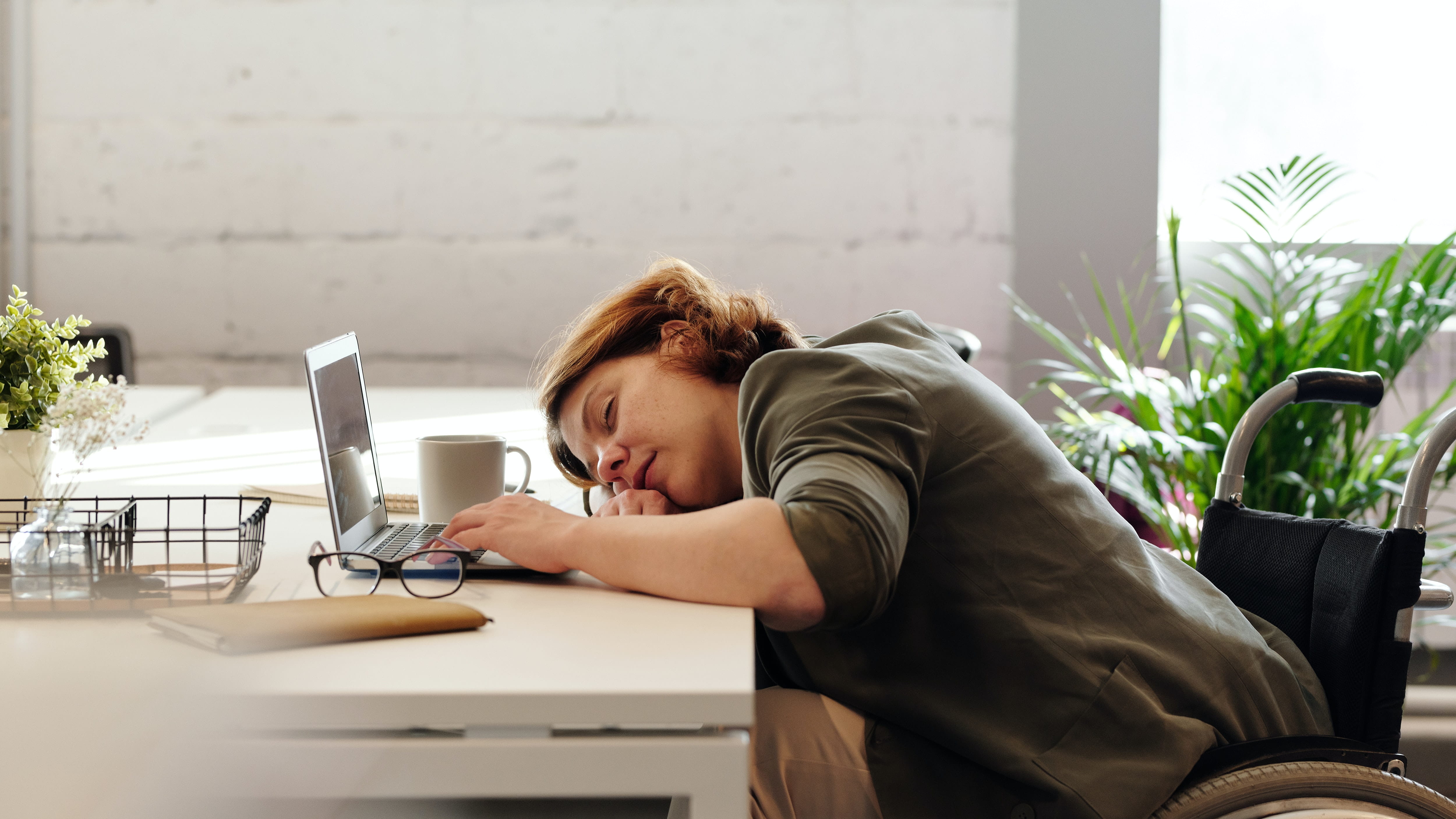 Woman taking a nap on her workstation in the afternoon