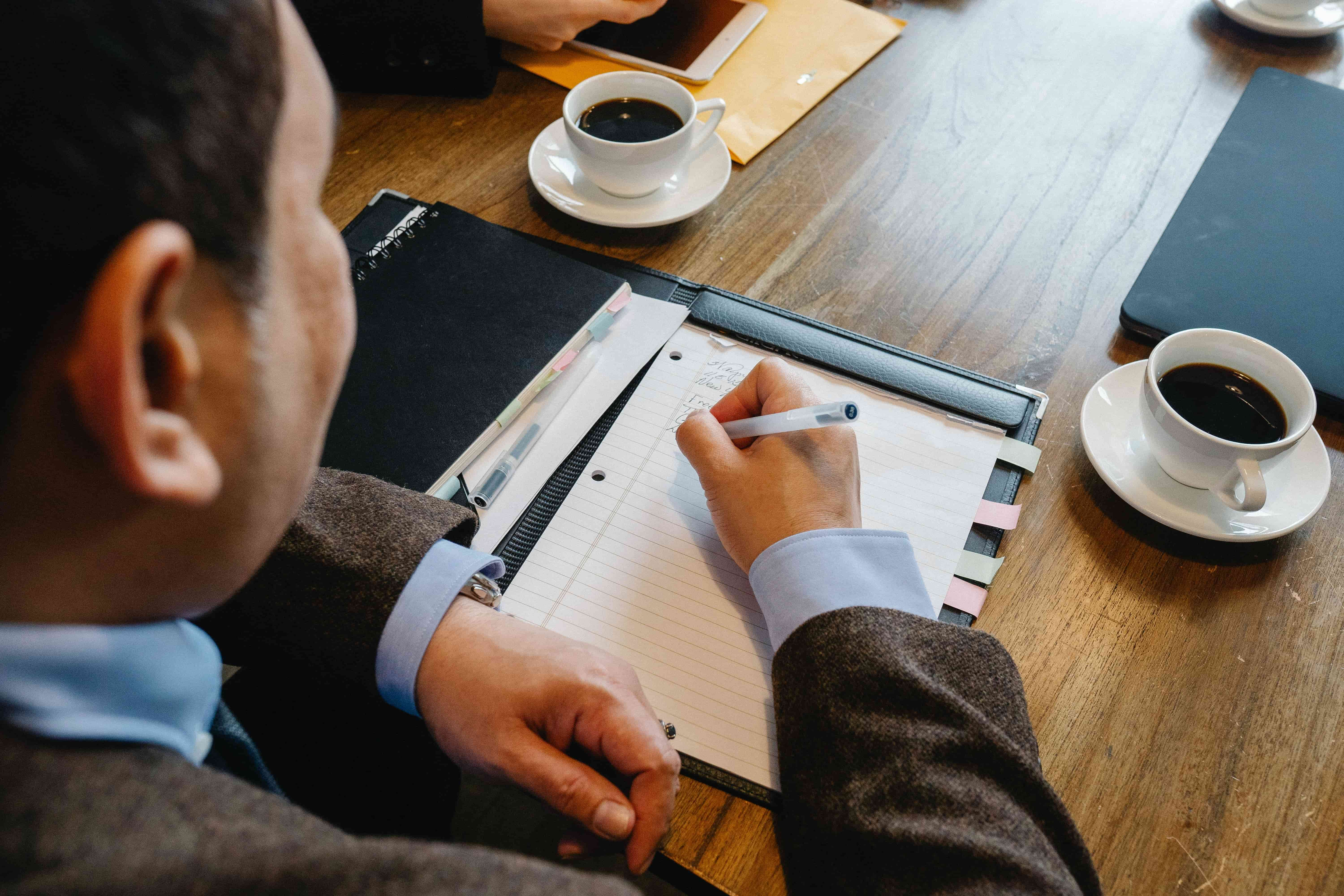 Man taking notes at a meeting